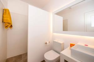 ein weißes Badezimmer mit Toilette und Waschbecken in der Unterkunft Villa Amatista by Villa Plus in Cala en Forcat + 27 Fotos