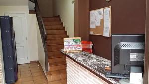 a room with a staircase and a counter with a television at Hostal Velarde in Talavera de la Reina