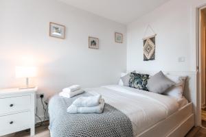 um quarto branco com uma cama com toalhas em City View Apart Central of Southampton 2-beds & 2-bath - Free private parking space em Southampton