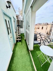 a small balcony with green grass on a building at El Pont Alicante Apartments in Alicante