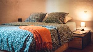 a bed with a blue comforter and pillows on it at Gîte La Source in Grusse