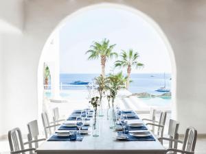 a long table with a view of the ocean at Mykonos Blu, A Grecotel Resort to Live in Psarou