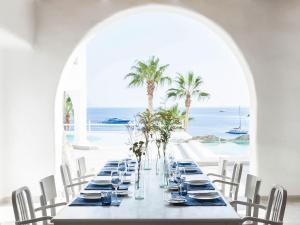 una mesa larga con vistas al océano en Mykonos Blu, Grecotel Boutique Resort, en Psarou