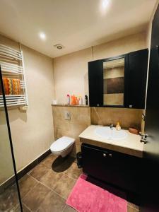 een badkamer met een wit toilet en een wastafel bij Very nice apartment near the city center & beach in Agadir