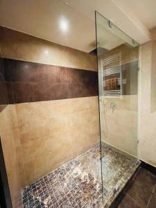 een badkamer met een douche en een glazen deur bij Very nice apartment near the city center & beach in Agadir