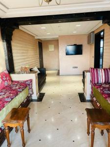 ein Wohnzimmer mit Sofas und einem Flachbild-TV in der Unterkunft Very nice apartment near the city center & beach in Agadir