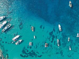 an aerial view of boats in the water at Mykonos Blu, A Grecotel Resort to Live in Psarou