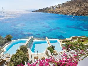 an aerial view of a resort with a swimming pool and the ocean at Mykonos Blu, A Grecotel Resort to Live in Psarou