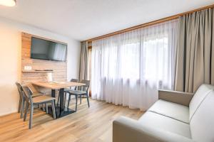 Habitación de hotel con mesa, sillas y sofá en Chalet Graben en Grindelwald