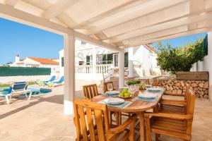 a dining room with a table and chairs and the ocean at Villa Santi III by Villa Plus in Cala'n Porter