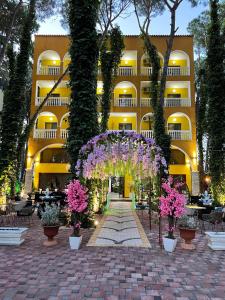 un hotel con un arco con flores delante en Hotel Mali i Robit, en Golem