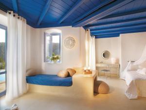 a bedroom with a bed with a blue ceiling at Mykonos Blu, A Grecotel Resort to Live in Psarou