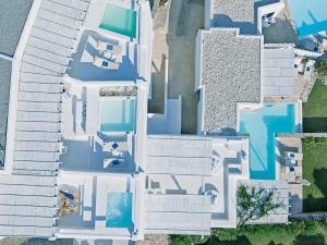 an aerial view of a white house with blue at Mykonos Blu, A Grecotel Resort to Live in Psarou