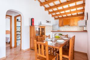 a kitchen and dining room with a wooden table and chairs at Villa Ingrid Porter by Villa Plus in Cala en Porter