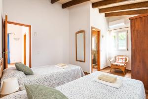 a white room with two beds and a chair at Villa Ingrid Porter by Villa Plus in Cala'n Porter +41 photos