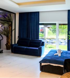 een slaapkamer met een blauw bed en een bank bij Apartament Księżycowy z jacuzzi in Nowy Sącz
