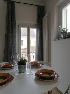 una mesa con platos y copas de vino y una ventana en Casa Bartelli - Ceriale en Ceriale