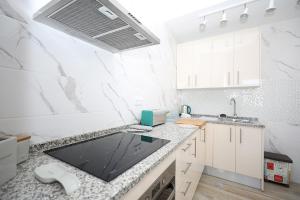 a kitchen with white marble counter tops and a sink at B50 - Main Square Apartment in Lagos in Lagos