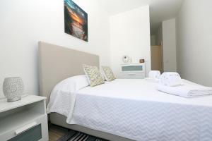 a white bedroom with a bed with white sheets and pillows at B50 - Main Square Apartment in Lagos in Lagos