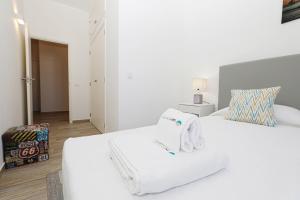a white bedroom with two beds with towels on them at B50 - Main Square Apartment in Lagos in Lagos