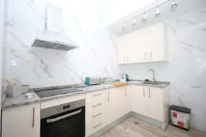 a white kitchen with a stove and a sink at B50 - Main Square Apartment in Lagos in Lagos