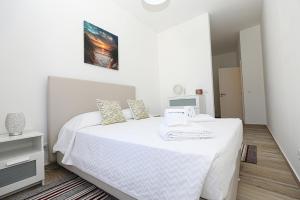 a white bedroom with a bed with white sheets at B50 - Main Square Apartment in Lagos in Lagos