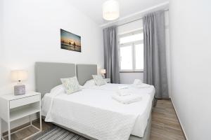 a white bedroom with a bed and a window at B50 - Main Square Apartment in Lagos in Lagos