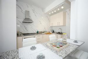 a white kitchen with a table with a bottle on it at B50 - Main Square Apartment in Lagos in Lagos