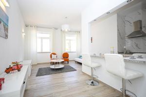 a white kitchen with two chairs and a table at B50 - Main Square Apartment in Lagos in Lagos