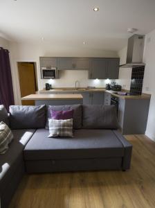 sala de estar con sofá y cocina en White Cottage - Cosy Holiday Cottage in Drymen, Loch Lomond & Trossachs, en Drymen
