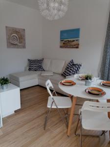 sala de estar blanca con mesa y sofá en Casa Bartelli - Ceriale en Ceriale