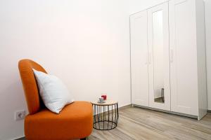 an orange chair with a pillow and a small table at B50 - Main Square Apartment in Lagos in Lagos