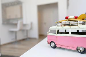 a pink and white toy van with surfboards on top at B50 - Main Square Apartment in Lagos in Lagos