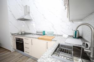 a white kitchen with a sink and a stove at B50 - Main Square Apartment in Lagos in Lagos