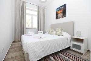 a white bedroom with a large bed and a window at B50 - Main Square Apartment in Lagos in Lagos