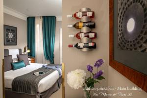 ein Hotelzimmer mit einem Bett und einer Flasche Wein an der Wand in der Unterkunft Condotti Boutique Hotel in Rom