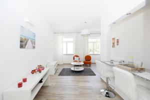a white living room with white furniture and orange chairs at B50 - Main Square Apartment in Lagos in Lagos