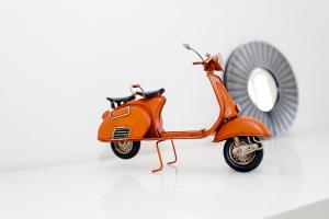 an orange scooter parked next to a mirror at B50 - Main Square Apartment in Lagos in Lagos