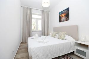 a white bedroom with a bed and a window at B50 - Main Square Apartment in Lagos in Lagos