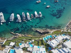a group of boats in the water next to a harbor at Mykonos Blu, A Grecotel Resort to Live in Psarou