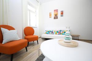 a living room with a white table and orange chairs at B50 - Main Square Apartment in Lagos in Lagos