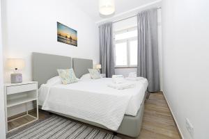 a white bedroom with a bed and a window at B50 - Main Square Apartment in Lagos in Lagos