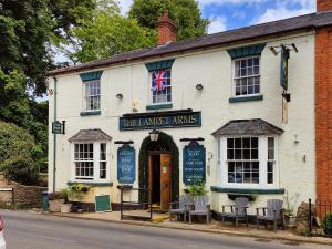 a white building with a sign that reads the laird arms at The Lampet Arms in Banbury