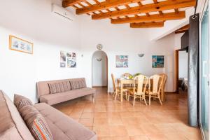 uma sala de estar com um sofá, uma mesa e cadeiras em Villa Santi I by Villa Plus em Cala'n Porter