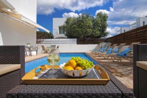 a table with a bowl of fruit and a glass of wine at Villa Nissinia in Ayia Napa