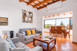 a living room with a couch and a table at Villa De La Luz by Villa Plus in Punta Prima