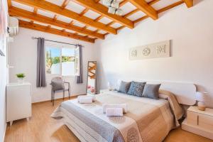 a white bedroom with a large bed and a window at Villa De La Luz by Villa Plus in Punta Prima