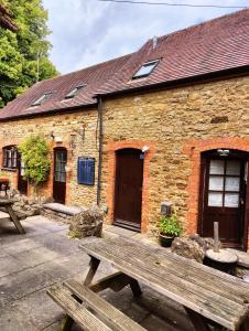 a brick building with a wooden bench in front of it at The Lampet Arms in Banbury +6 photos
