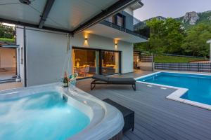 een hot tub op een terras naast een zwembad bij Villa Saric in Bribir
