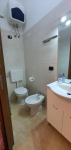 een badkamer met een toilet, een wastafel en een spiegel bij Stella Marina in Genua +12 foto's